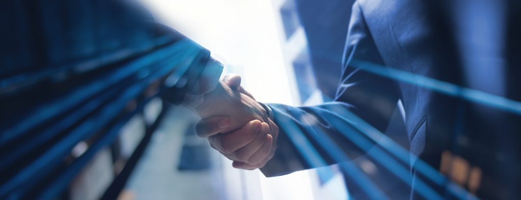 Two businesspeople shaking hands, indicating successful deal